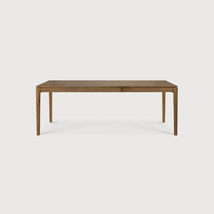 Teak Bok Extendable Dining Table side view with white background, featuring floating table top and beautiful wood joinery. - Saffron and Poe, Ethnicraft