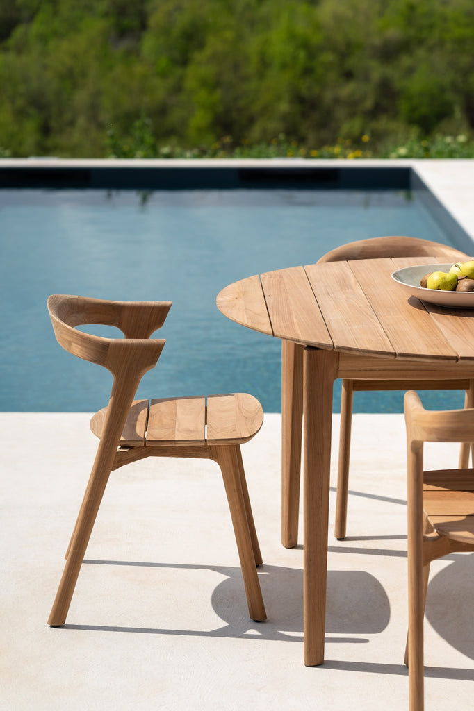 Bok Outdoor Dining Chairs with Bok Outdoor Dining Table Round, styled with a bowl of seasonal fruit, next to a modern pool. - Saffron and Poe, Ethnicraft