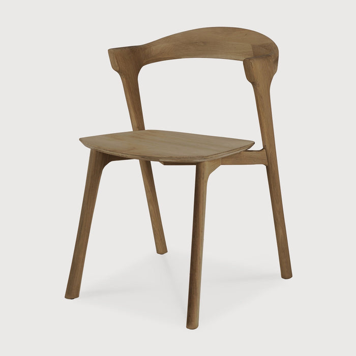 Natural Teak Bok Dining Chair angle view with white background and beautiful wood joinery. - Saffron and Poe, Ethnicraft