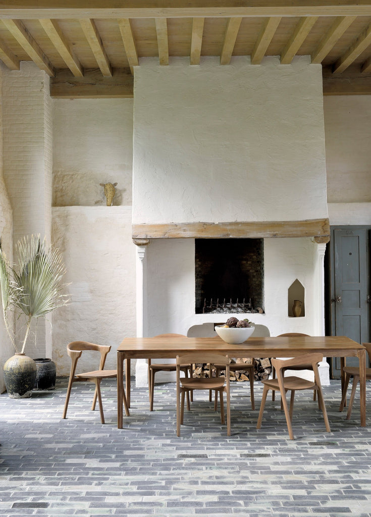 Teak Bok Dining Table and Chairs in European inspired dining room with high ceilings and exposed beams, plaster fireplace and paver floors. - Saffron and Poe, Ethnicraft