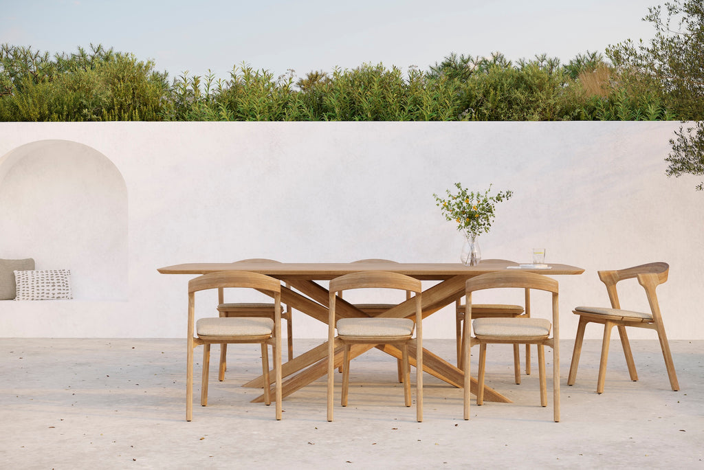 Mikado Outdoor Dining Table with Bok Outdoor Dining Chairs and natural cushion seat on an outdoor patio styled with simple florals. - Saffron and Poe, Ethnicraft