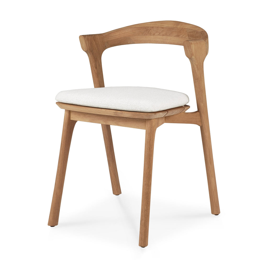 Teak Bok Outdoor Dining Chair angle view with off white cushion on a white background and beautiful wood joinery. - Saffron and Poe, Ethnicraft