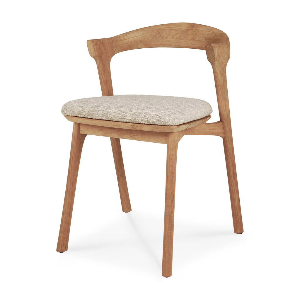 Teak Bok Outdoor Dining Chair angle view with natural cushion on a white background and beautiful wood joinery. - Saffron and Poe, Ethnicraft