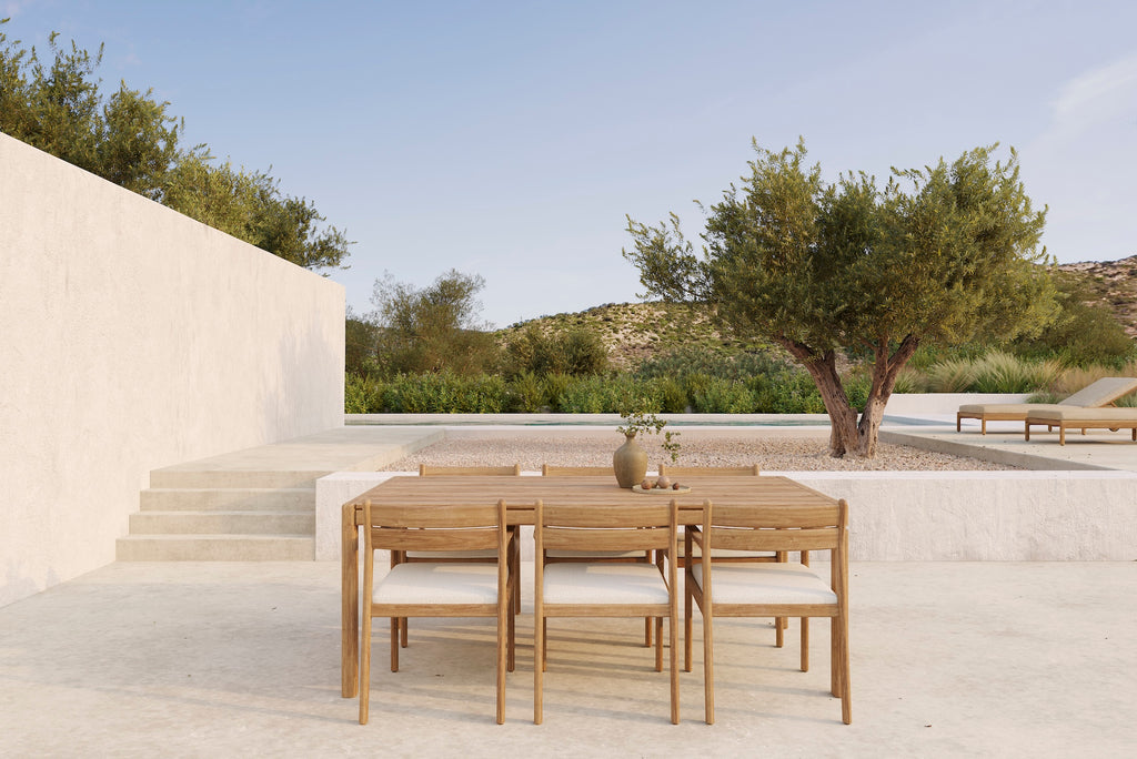 Jack Outdoor Dining Chairs and natural cushion seat with Jack Outdoor Dining Table on an outdoor patio against a off white cement wall. - Saffron and Poe, Ethnicraft