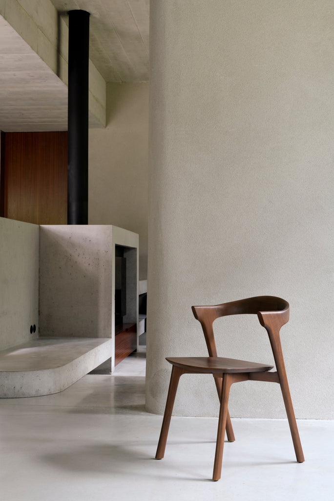Dark Teak Bok Chair in bright modern room with a fireplace and concrete floors. - Saffron and Poe, Ethnicraft