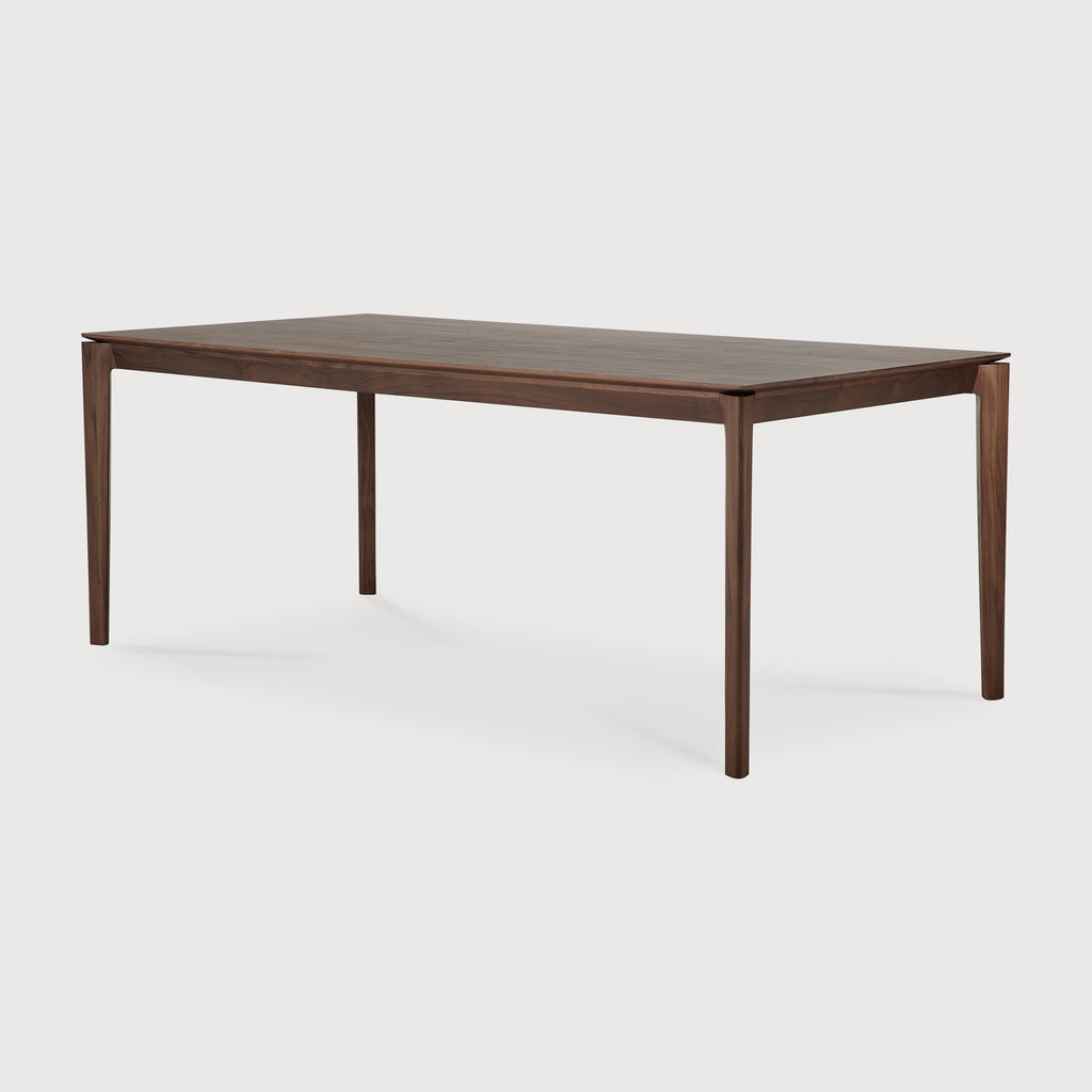 Darkened Teak Bok Dining Table angle view with white background, featuring floating table top and beautiful wood joinery. - Saffron and Poe, Ethnicraft