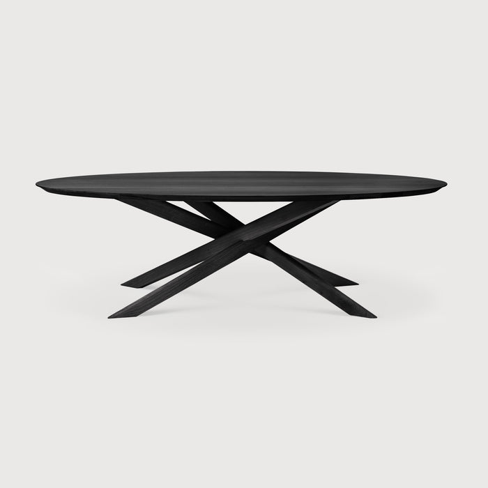 Black Oak Oval Mikado Dining Table front angle with white background and beautiful intersecting wood legs. - Saffron and Poe, Ethnicraft