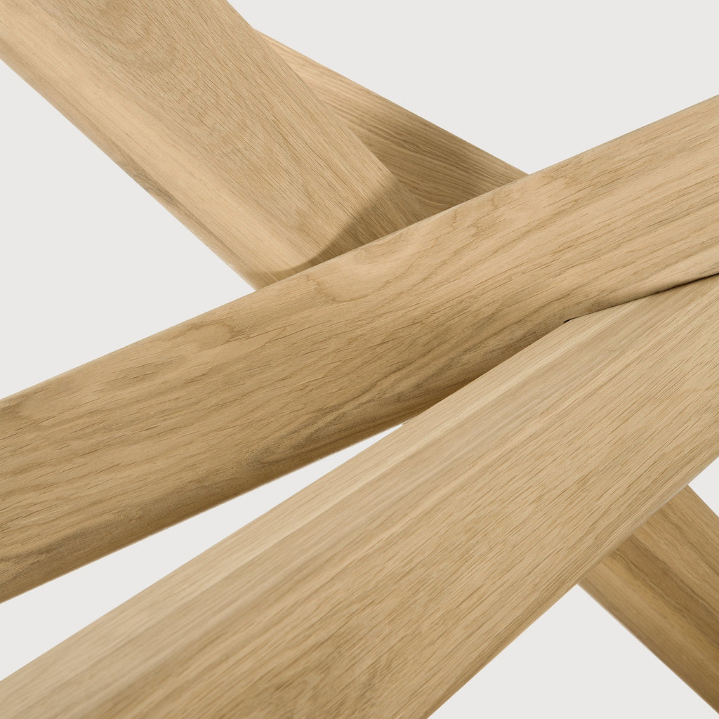 White Oak Oval Mikado Dining Table detail with white background and beautiful intersecting wood legs. - Saffron and Poe, Ethnicraft
