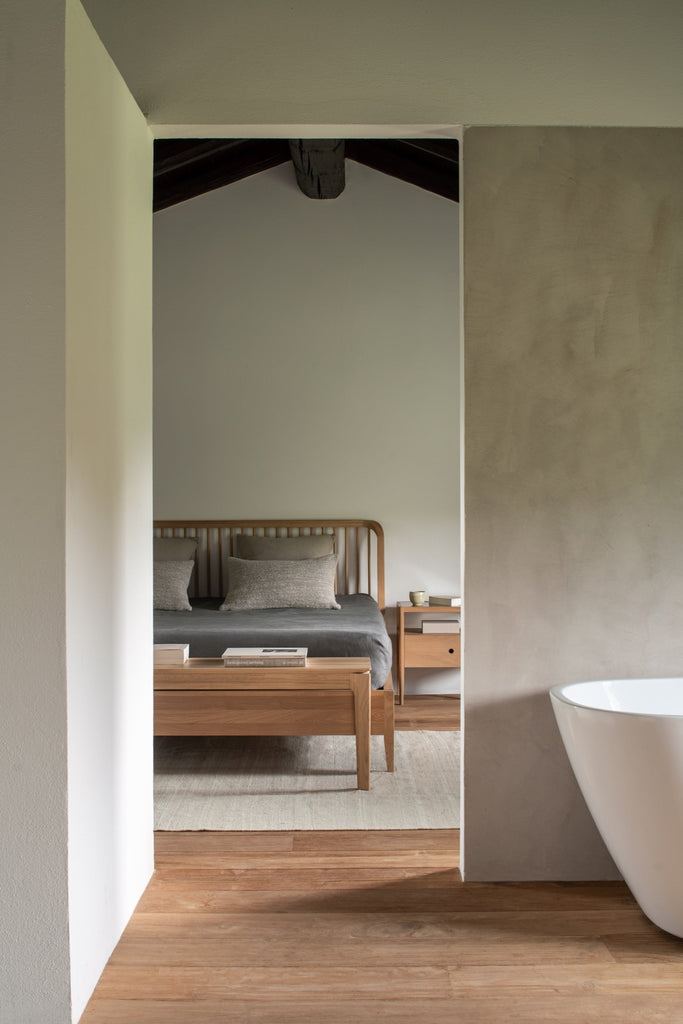 White Oak Bok Bench and spindle bed in Plastered modern bedroom with high ceilings with exposed beams. - Saffron and Poe, Ethnicraft