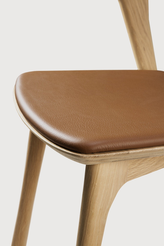 White Oak Bok Dining Chair with saddle leather seat detail with white background and beautiful wood joinery. - Saffron and Poe, Ethnicraft