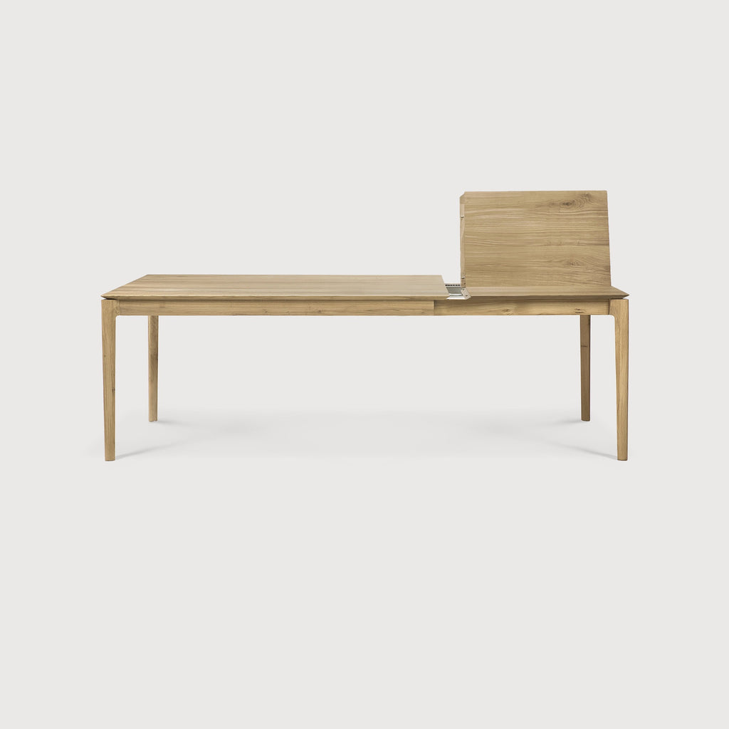 Oak Bok Extendable Dining Table side view with white background and extension mechanism with table leaf, featuring floating table top and beautiful wood joinery. - Saffron and Poe, Ethnicraft