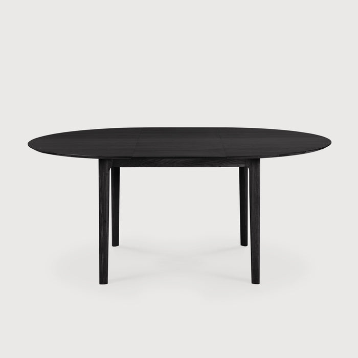 Black Oak Bok Round Extendable Dining Table side view in expanded position with white background, featuring floating table top and beautiful wood joinery. - Saffron and Poe, Ethnicraft