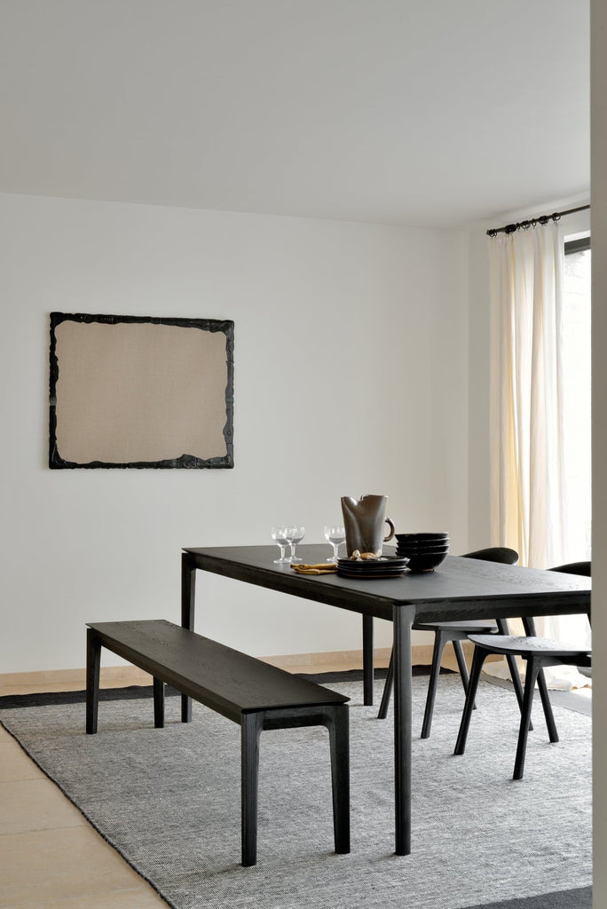 Black Oak Bok Bench, Bok dining chairs and Bok dining table in Bright Modern European inspired dining room with kilim rug and modern art. - Saffron and Poe, Ethnicraft