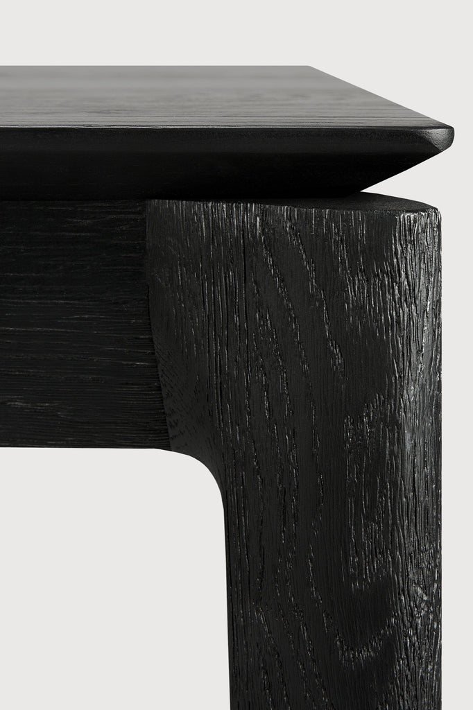 Black Oak Bok Extendable Dining Table close up detail with white background featuring floating table top and beautiful wood joinery. - Saffron and Poe, Ethnicraft
