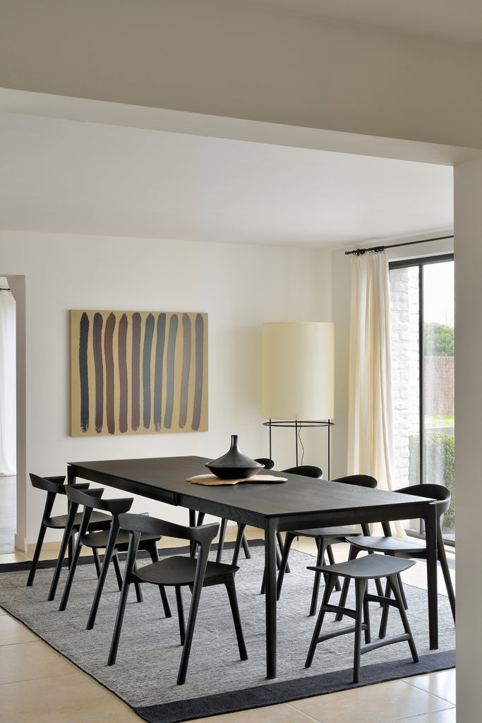 Black Oak Bok Extendable Dining Table in dining room with area rug, art and floor lamp, featuring floating table top and wood joinery. - Saffron and Poe, Ethnicraft
