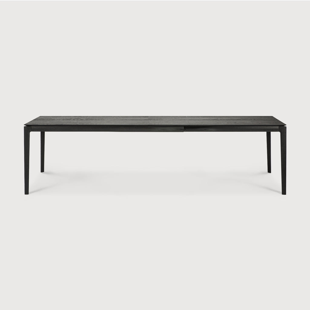 71”/110.5” long Black Oak Bok Extendable Dining Table side view with white background, featuring floating table top and beautiful wood joinery. - Saffron and Poe, Ethnicraft