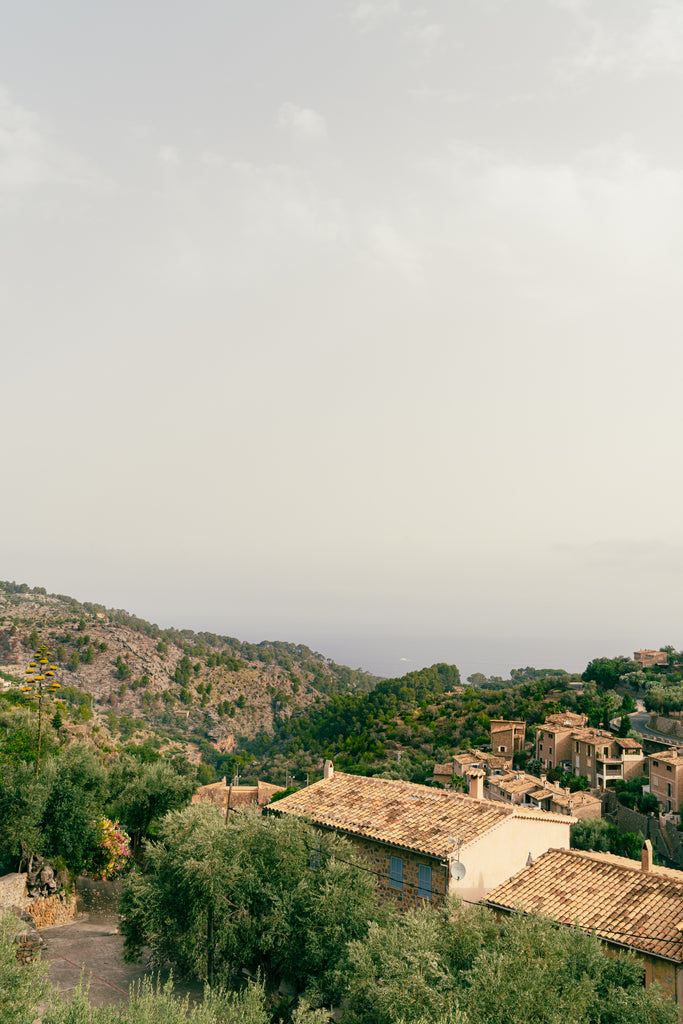 Photo of terracotta rooftops in seaside village of Deia by Mika Street for Saffron and Poe