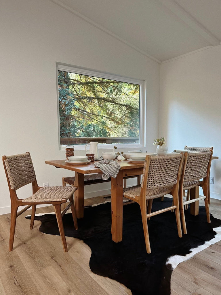 Woven Faux Rattan Marin Dining Chair styled in a dining room setting. - Saffron and Poe