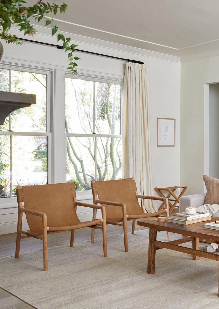 Leather Sling Lounge Chair styled in a living room setting with Vintage Coffee Table and Leather Folding Stool. - Saffron and Poe