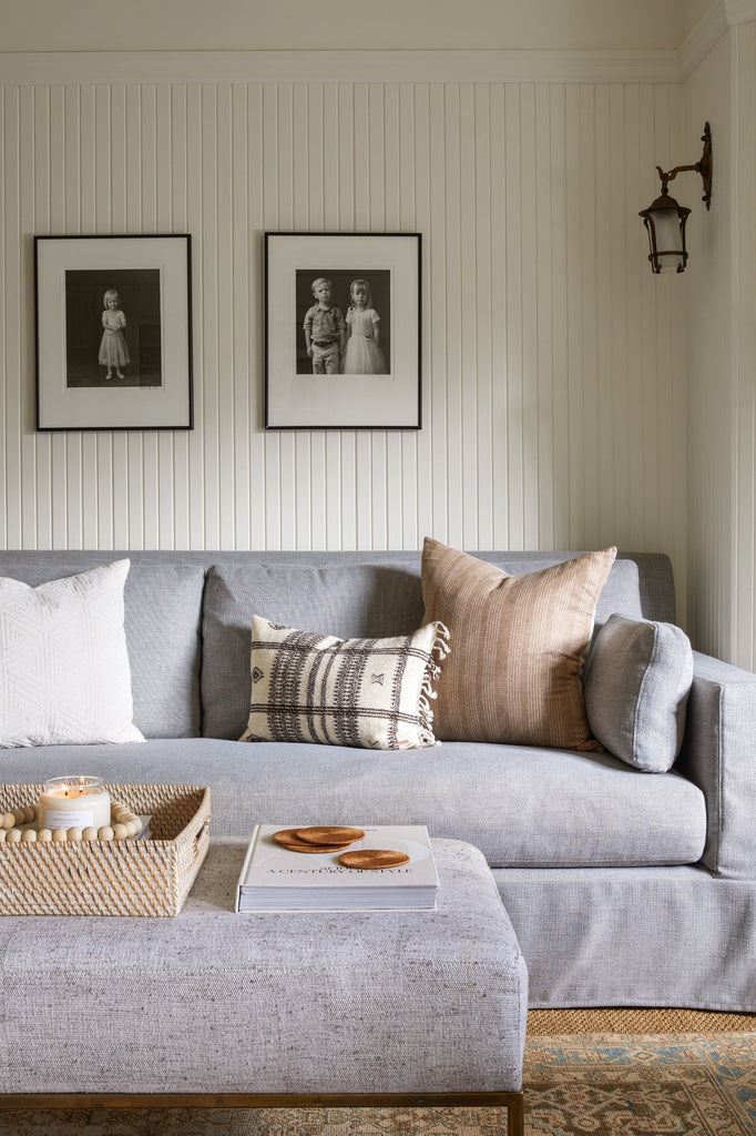 Beige Embroidered Pillow styled in a living room with Bhujodi Lumbar Pillow, Lombok Basket Tray, Bali Beads, and Tenganan Coasters. - Saffron and Poe