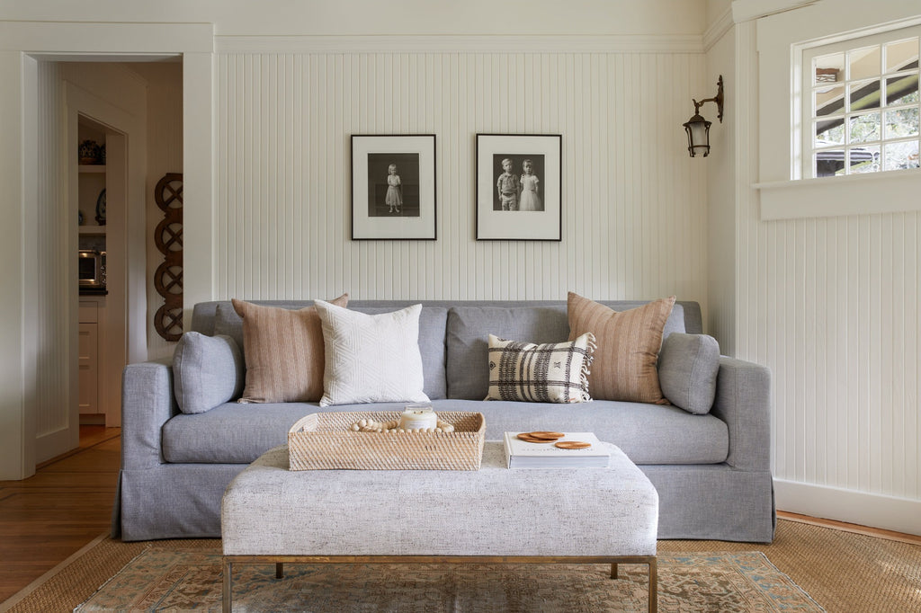 Lombok Basket Tray styled in a living room setting with Beige Embroidered Pillow, Ivory Pillow, and Bhujodi Lumbar Pillow. - Saffron and Poe