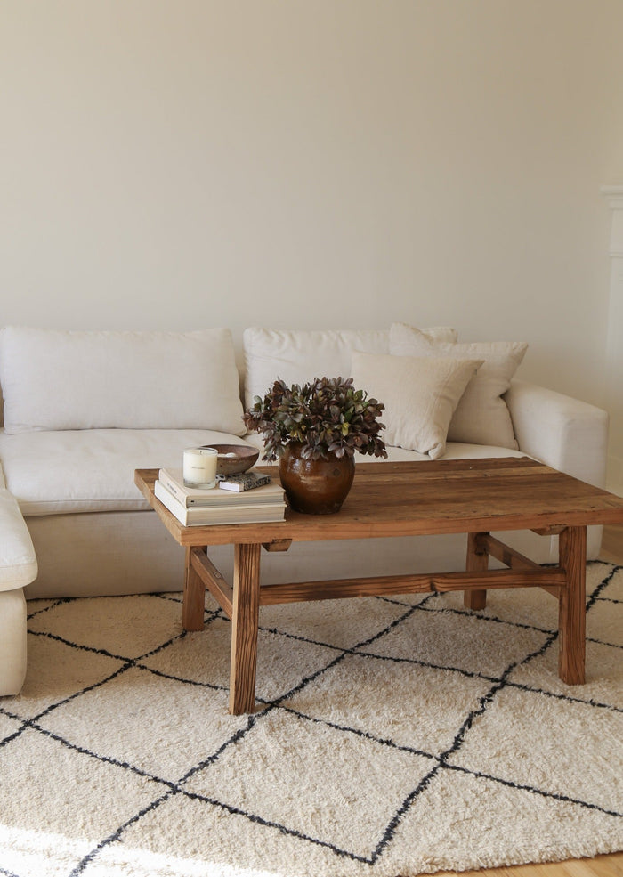 Styled view of Vintage Wood Coffee Table in a living room setting on a Beni Ourain Rug. - Saffron + Poe