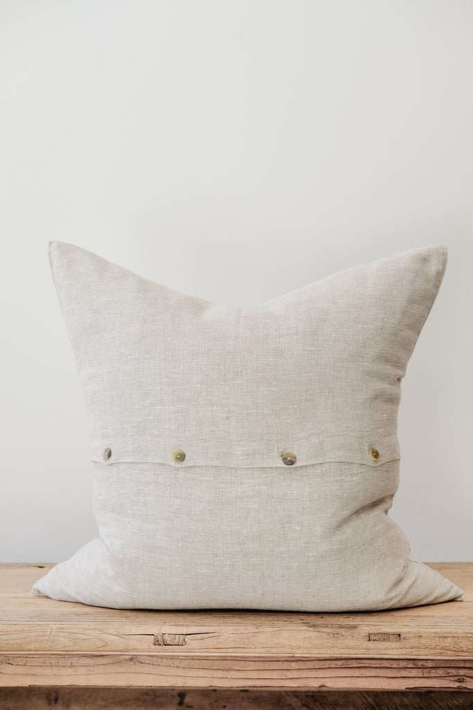 Back view of No. 50 - Natural Linen Pillow on an Antique Bench against a white wall. - Saffron and Poe