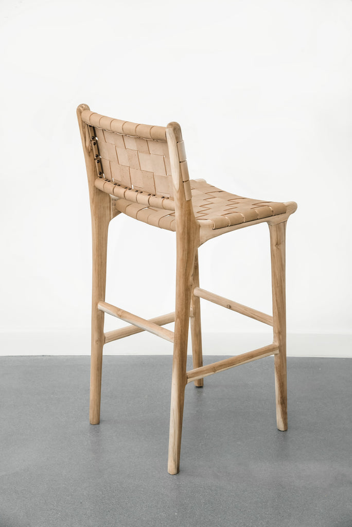 Rear view of our comfortable, casual, Woven leather strap bar stool in beige. Handmade in Bali using Teak wood and vegetable-tanned leather imported from Java. - Saffron and Poe