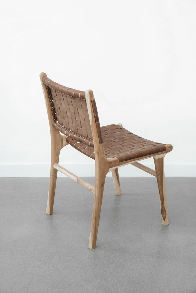Side profile of our Woven Leather Strap Dining Chair - Saddle on white background. Handmade in Bali with Teak wood and vegetable-tanned leather imported from Java. - Saffron and Poe