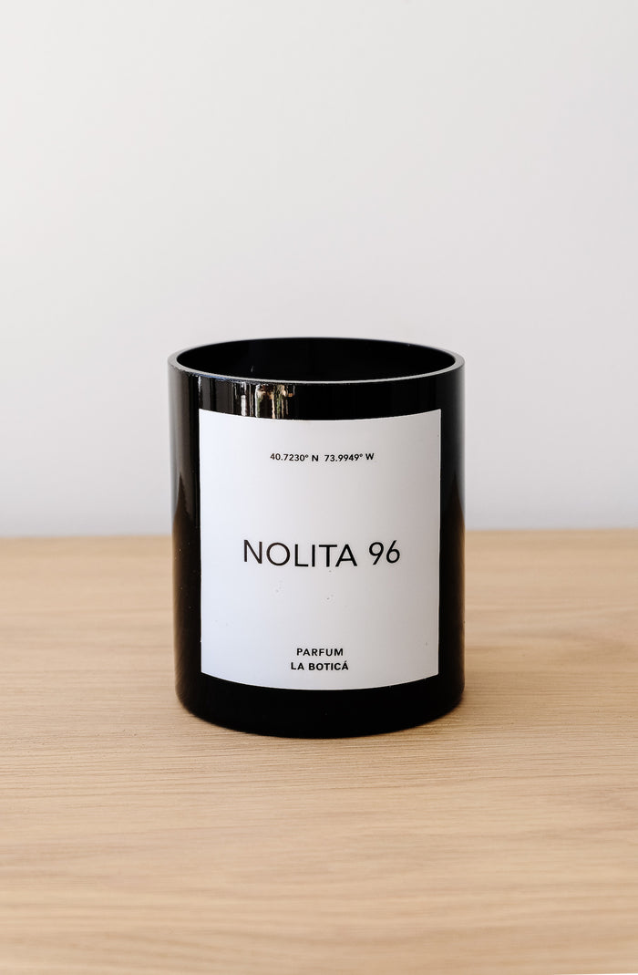 Front view of La Botica Nolita Candle on an oak table against a white wall. - Saffron and Poe 