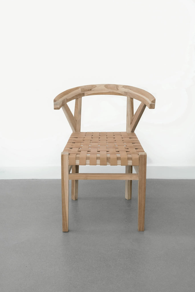 Front view of one curved wood and woven beige leather dining chair inspired by the wishbone Chair on white background. Handcrafted in Bali with Teak wood and vegetable-tanned leather imported from Java. - Saffron and Poe