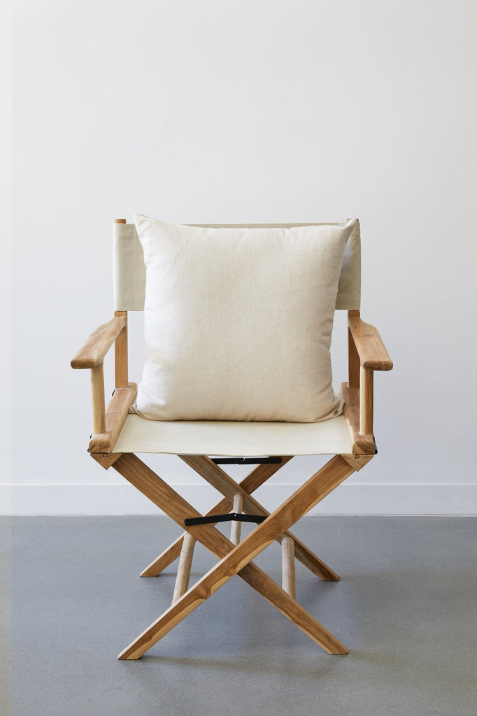 Ivory Director's Chair Pillow and our Oatmeal Director's Chair against a white background and concrete flooring. - Saffron and Poe