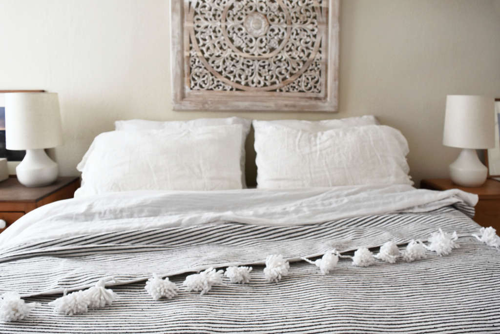 Bohemian bedroom linens styled with Moroccan Pom Bed Throw - Dark Grey and White Stripes. Hand-woven in Marrakech using wooden looms. - Saffron and Poe