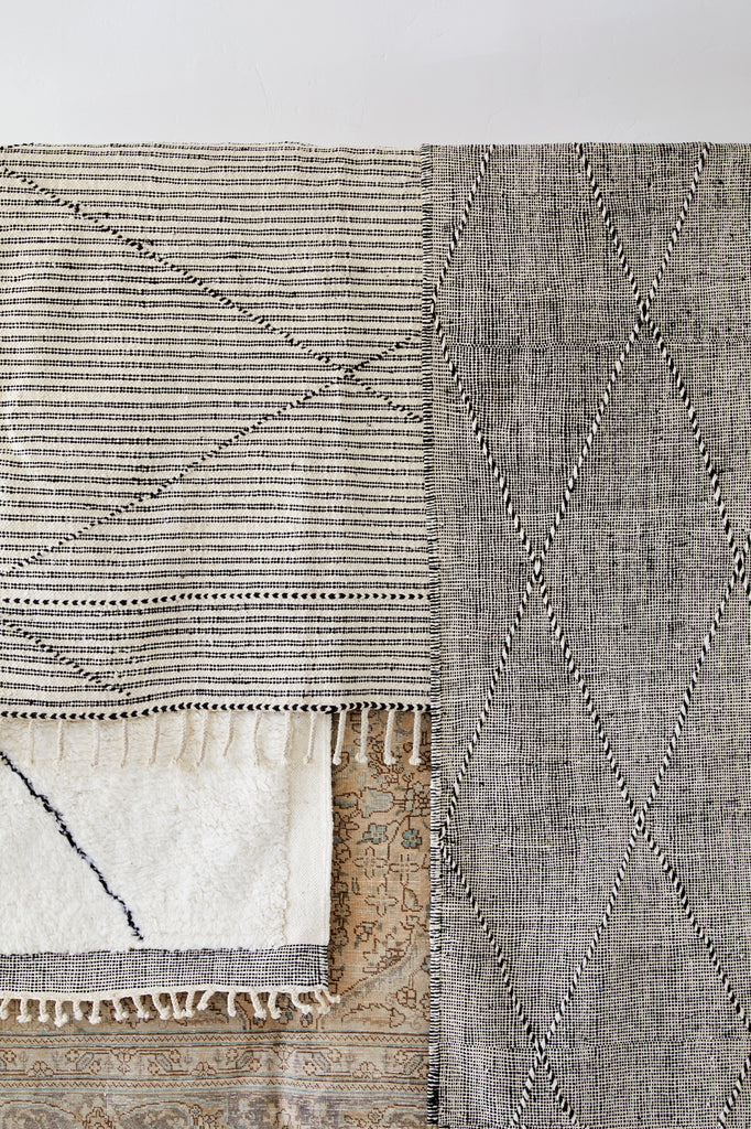 Detailed view of layered rugs. - Saffron + Poe