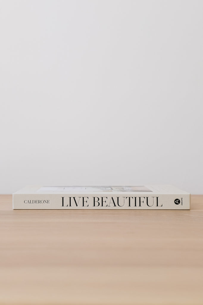 Side view of Live Beautiful against a white wall - Saffron and Poe