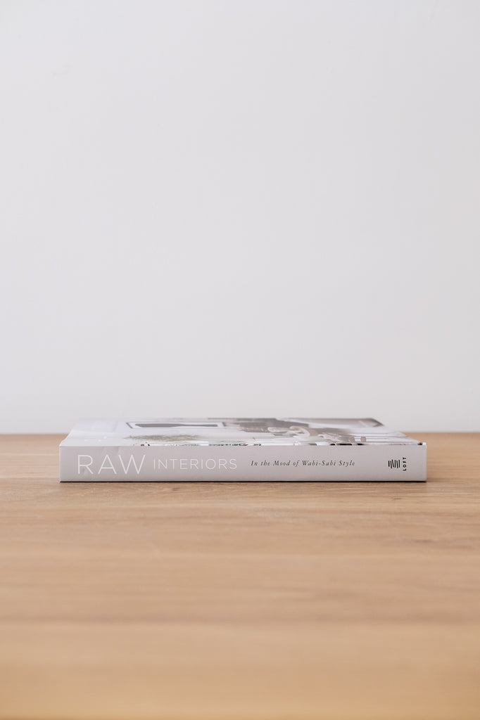 Side view of Raw Interiors on an Oak Dining Table against a white wall. - Saffron and Poe