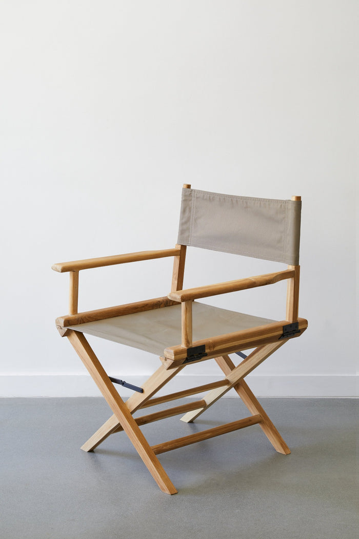 Side view of Taupe Canvas Director's Chair against white background on concrete flooring. - Saffron and Poe