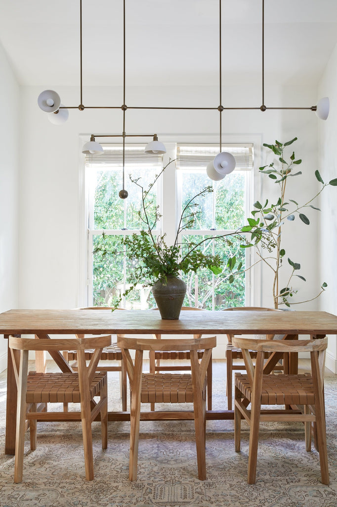Cropped styled photo with Vintage Mijiu Jar on top of oak table with Woven Leather Wishbone Dining Chairs. -Saffron and Poe