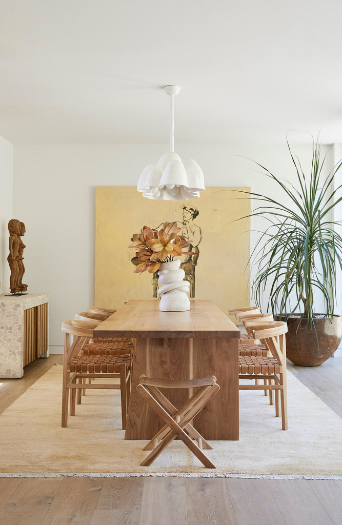 Styled Leather Folding Stool with a custom dining table and curved back woven leather strap dining chairs. - Saffron and Poe