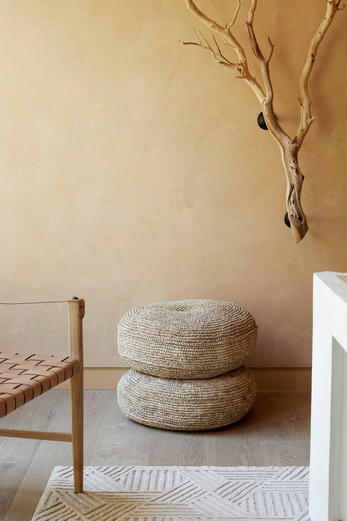 Styled Natural Woven Hyacinth Poufs stacked on top of each other with a Leather Strap Safari Lounge. - Saffron and Poe