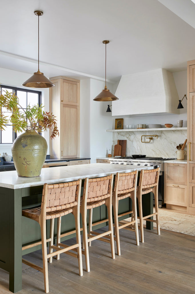 Styled view of Woven Leather Strap Counter Stool - Beige in a green kitchen. - Saffron and Poe