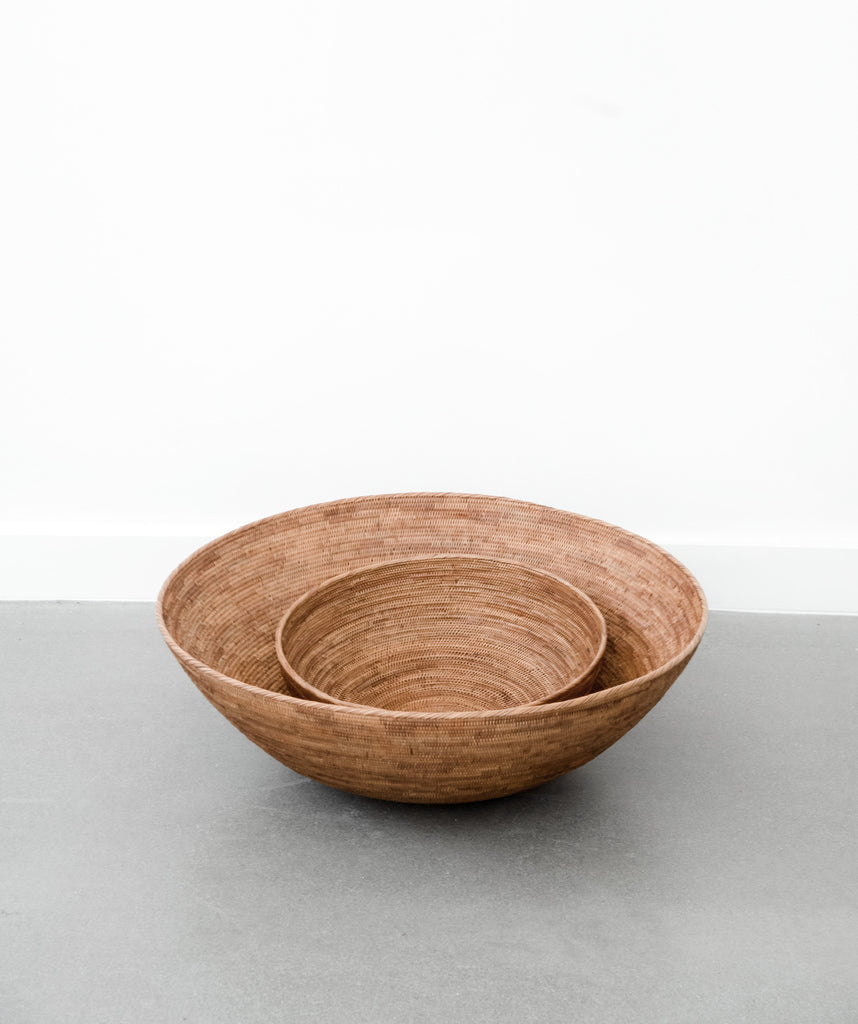 Two closeup stacked Woven Tenganan accent storage basket for magazines, fruit bowl for kitchen counter. Handwoven in Tenganan, Bali using Ata reed on a white background. - Saffron and Poe