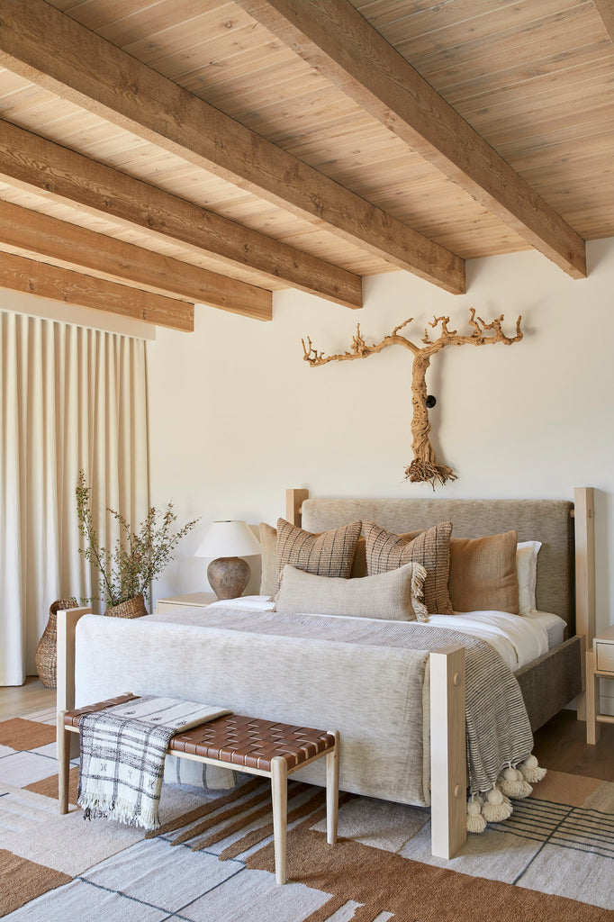 Styled Woven Leather Strap Bench - Saddle in a neutral bedroom with Handwoven Bhujodi Blanket and a Moroccan Pom Pom Throw Blanket. - Saffron and Poe