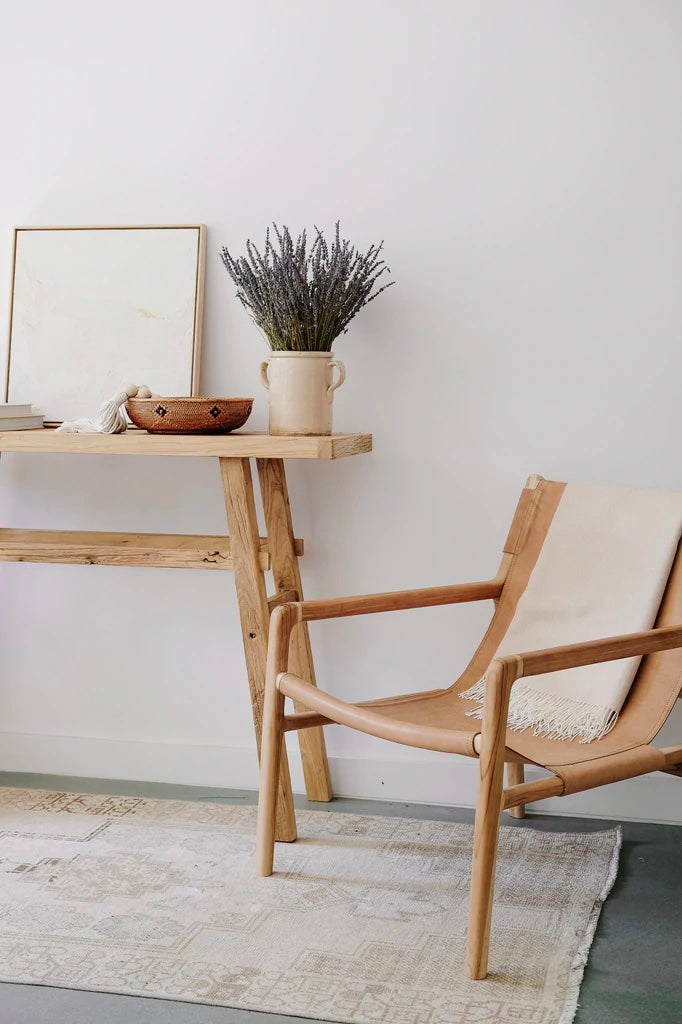 Styled Vintage Elmwood Console with Leather Slingback Lounge on a Vintage Turkish Rug. - Saffron and Poe