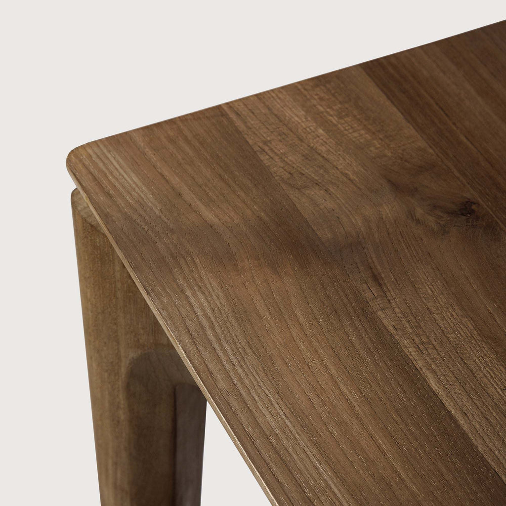Bok extendable dining table made of natural teak with a contoured frame and floating top