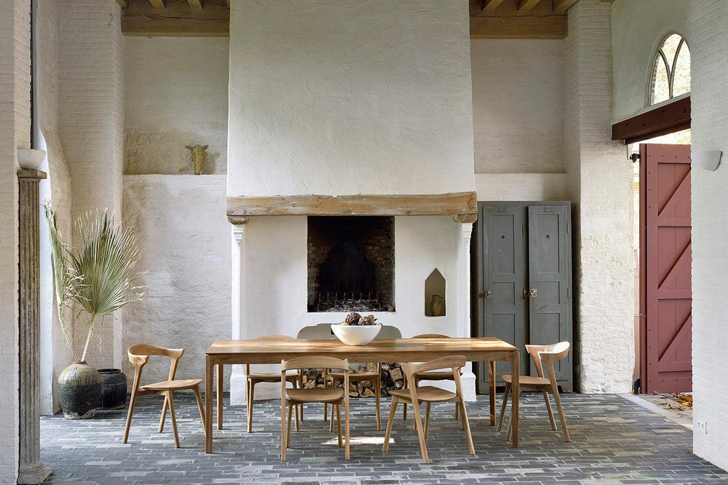 Bok Extendable Dining Table made of natural teak with contoured frame and floating top in a dining room setting
