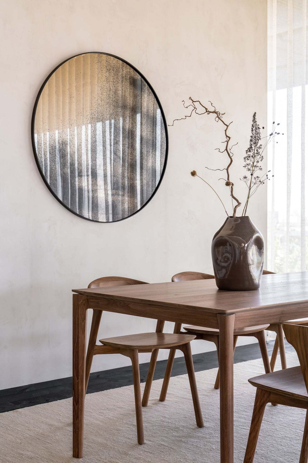 Bok Dining Table made of natural teak with contoured frame and floating tabletop in a modern dining room