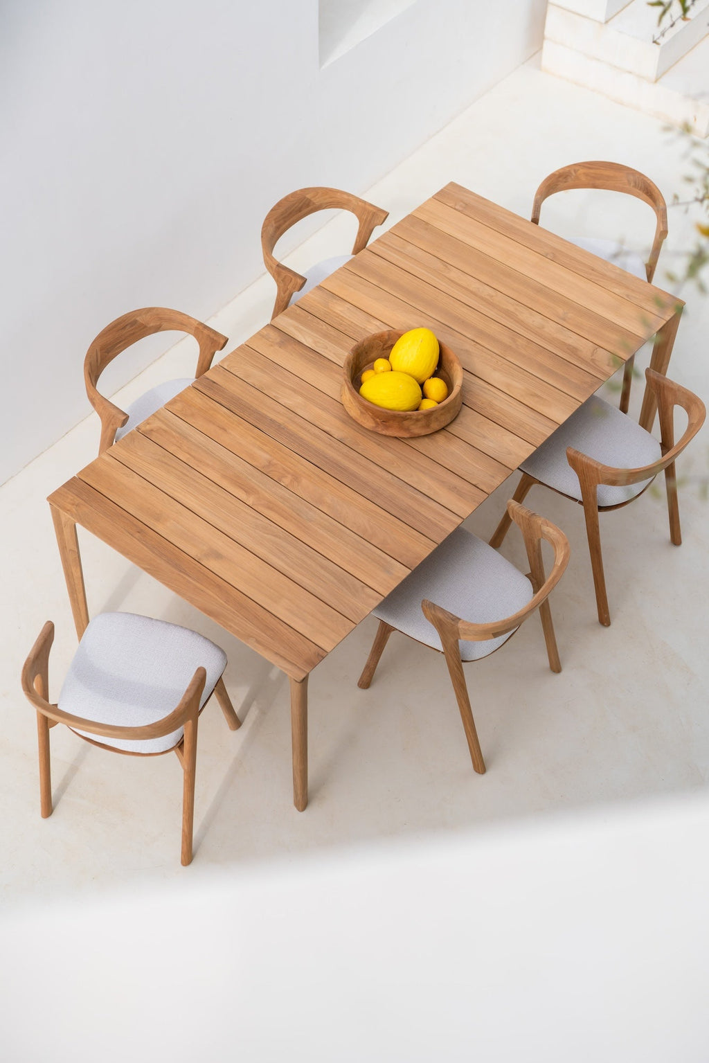 Bok Outdoor Dining Chair with sculptural teak frame and neutral fabric cushion