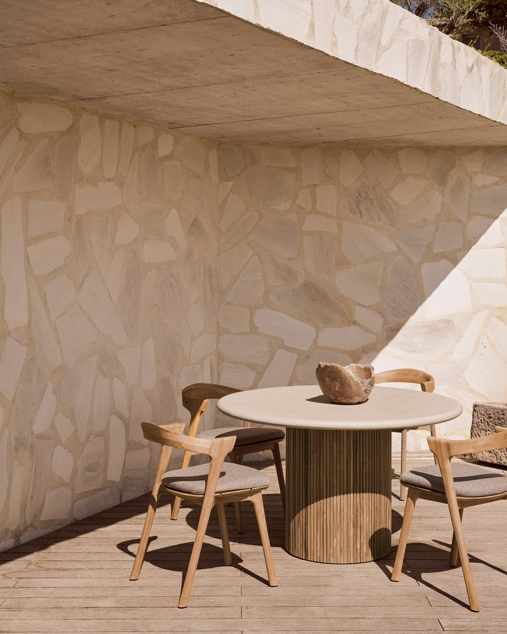 Roller Max Outdoor Dining Table with hand-finished concrete top and reclaimed teak base in stacked wood-stick design