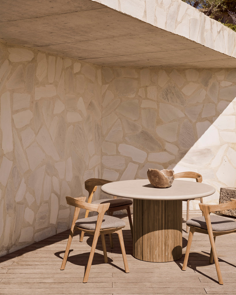 Round outdoor table with slatted reclaimed teak base and concrete table top styled on deck with Bok Dining Chairs. - Saffron and Poe, Ethnicraft